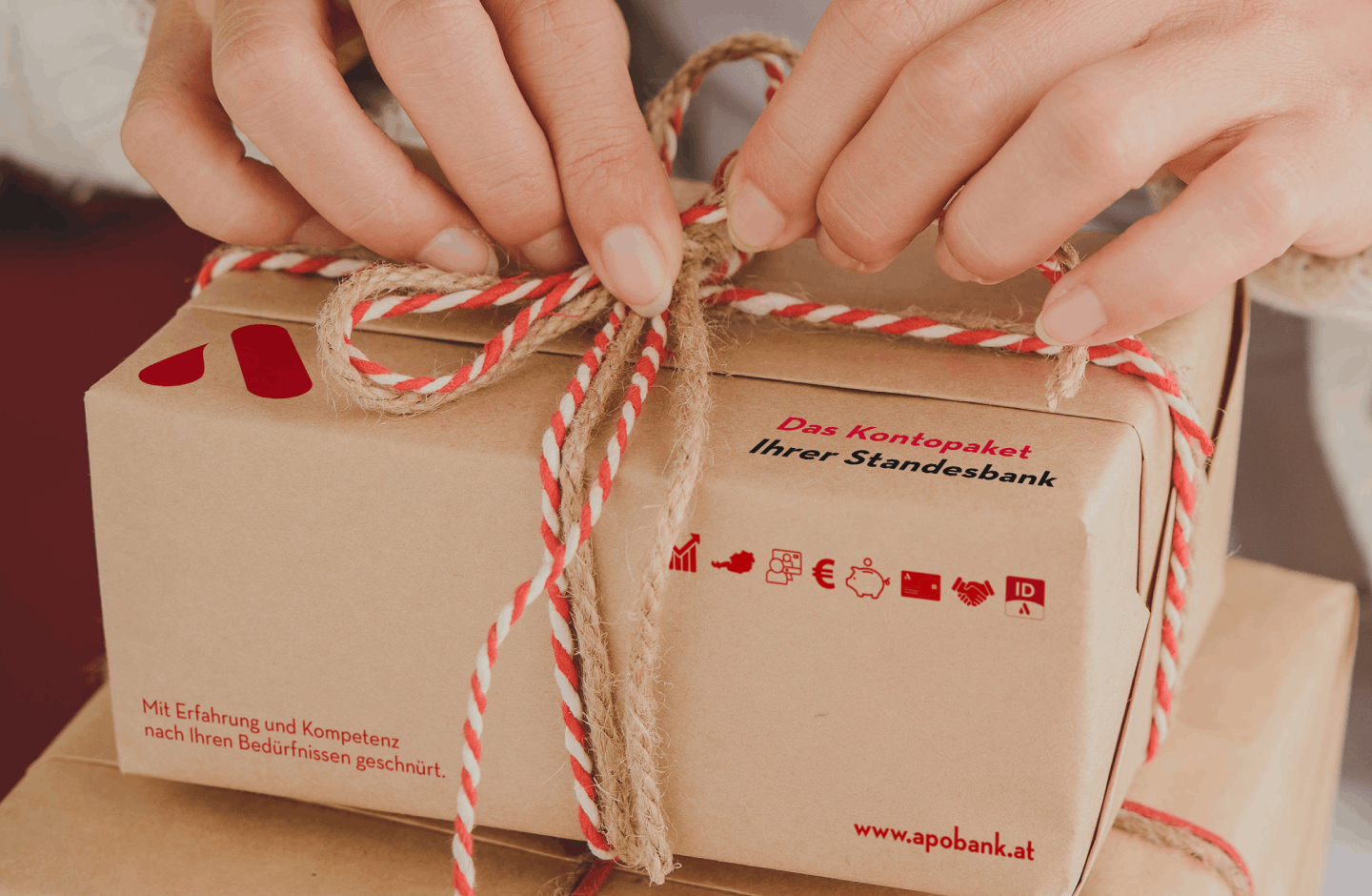 Frauenhände, die ein Paket schnüren