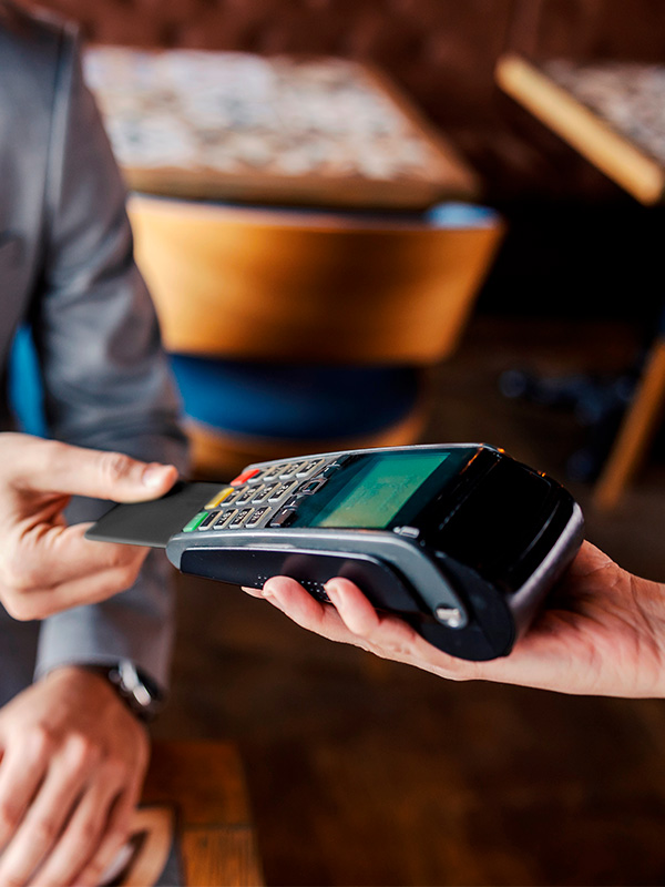 Eine Person bezahlt bei einem Terminal mit der Volksbank Debit Mastercard Business